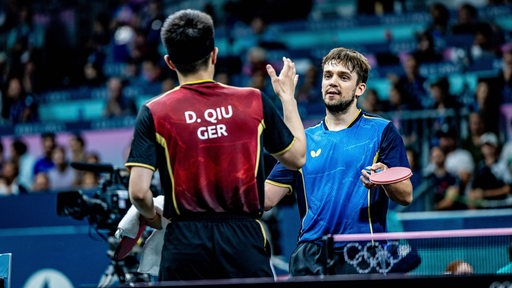 Kirill Gerassimenko und Dang Qiu setzen nach dem Spiel zum Handschag an.