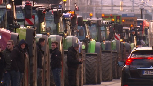 Eine lange Schlange von Trekkern steht auf einer Straße.