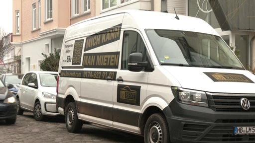 Ein Transporter einer Autovermietung parkt in einer Wohnstraße.