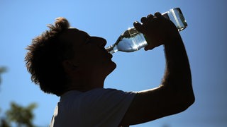 Ein Mann trinkt aus einer Wasserflasche