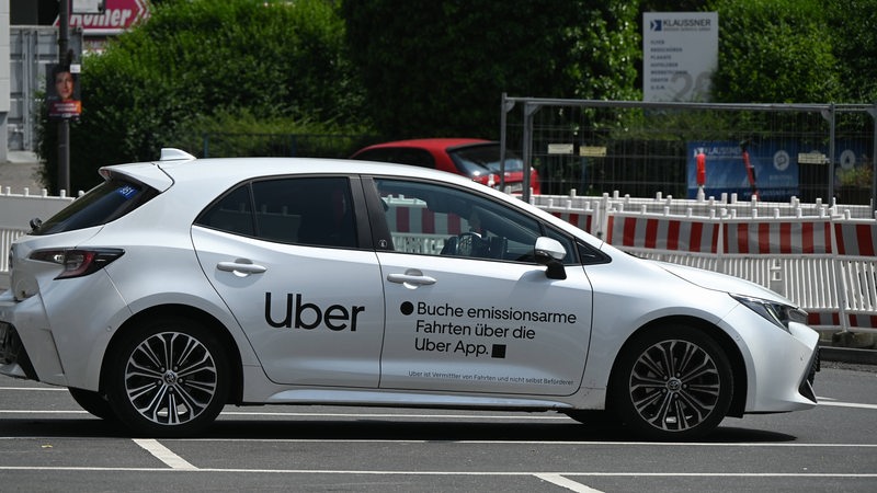 Ein Fahrzeug vom Fahrtenvermittler Uber steht auf einem Parkplatz.