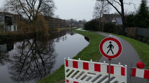 Ein Weg in einem Wohngebiet ist wegen des Hochwassers gesperrt.