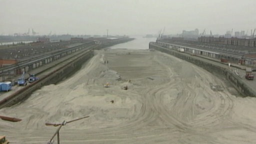 Bremen verfüllt Ende der 90er das marode Becken des Überseehafens mit Sand.