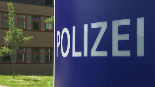 Es ist ein Schild mit der Aufschrift "Polizei" zu sehen.