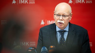 Bremens Innensenator Ulrich Mäurer, Vorsitzender der Innenministerkonferenz sitzt vor Mikrofonen