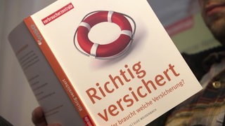 Auf einem Buch steht "Richtig versichert - Wer braucht welche Versicherung?".