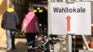 Ein Schild zeigt den Weg zu den Wahllokalen.