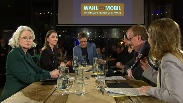 Politiker beim Wahlmobil-Talk in der Union-Brauerei: Kirsten Kappert-Gonther (Grüne), Sandra Schmull (CDU), Felix Krömer (Moderator), verdeckt ist Ulrike Hiller (SPD), Volker Redder (FDP) und Doris Achelwilm (Linke)