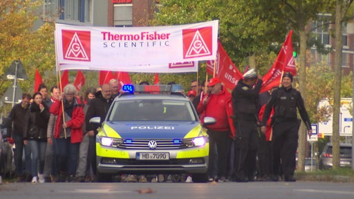 Ein Streik in einer Bremer Straße mit Plakaten und Polizei.