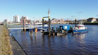 Ein paar Boote liegen an einem Hafen im Wasser