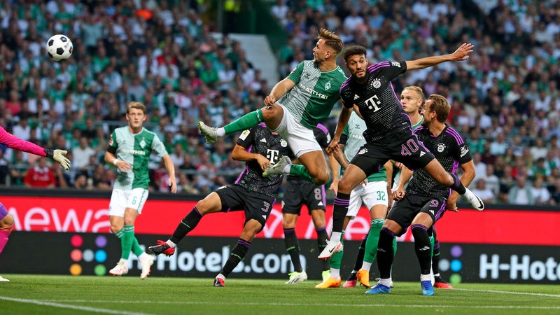 Niclas Füllkrug schießt artistisch en Tor gegen Bayern. 