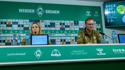 Werder-Spielerin Nina Lührßen und Trainer Thomas Horsch sitzen während einer Pressekonferenz auf dem Podium