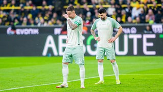 Marco Friedl und Anthony Jung schauen frrustriert auf dem Platz im Dortmunder Stadion.