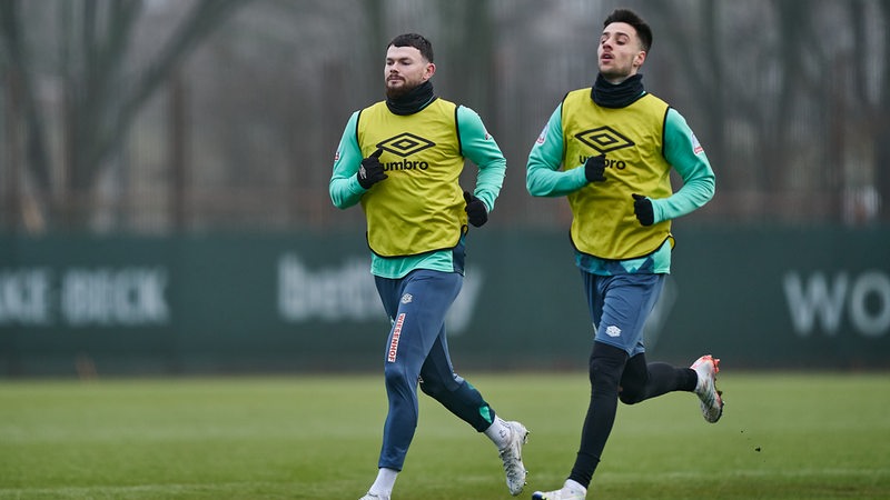 Die Werder-Spieler Oliver Burke und Ilia Gruev rennen beim Training über den Platz.