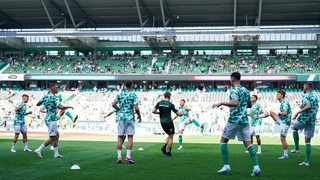 Werder-Spieler wärmen sich vor einem Bundesliga-Spiel im Weser-stadion auf.