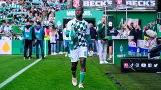 Naby Keita läuft im Weser-Stadion zur Ersatzbank.