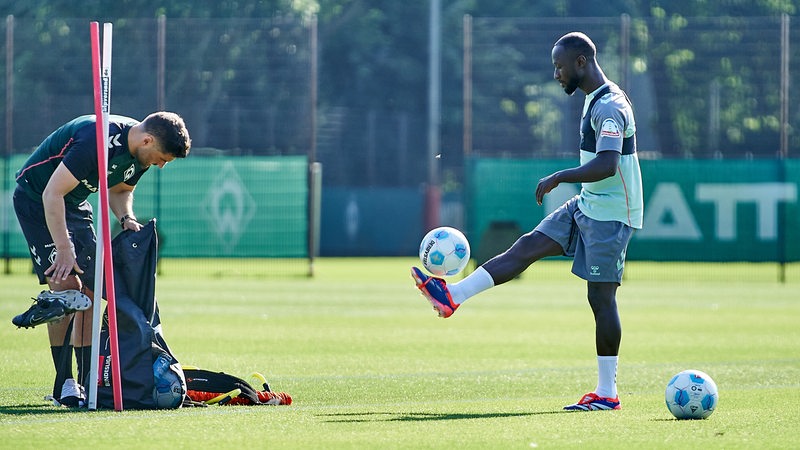 Der Werder-Spieler Naby Keita hält beim Training den Ball hoch. 