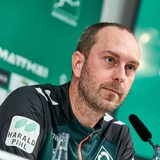 Ole Werner sitzt bei der Pressekonferenz auf dem Podium. 