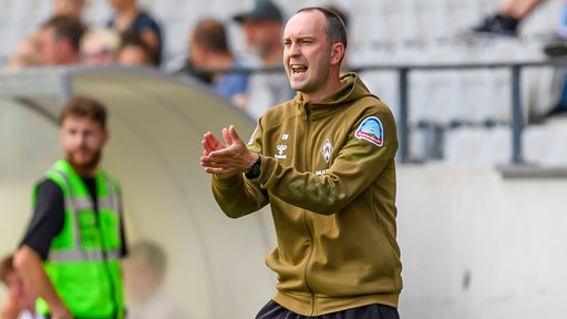 Ole Werner klatscht am Spielfeldrand in die Hände.