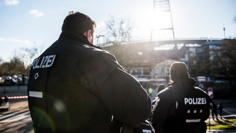 Ein Mann steht in Polizei-Uniform vor dem Bremer Weser-Stadion