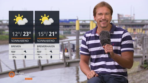 Wettermoderator Andree Pfitzner an der Weser, links die Wettertafeln.