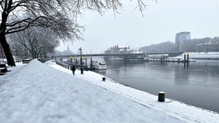 Die Weser und die Wege am Wasser entlang sind eingeschneit.