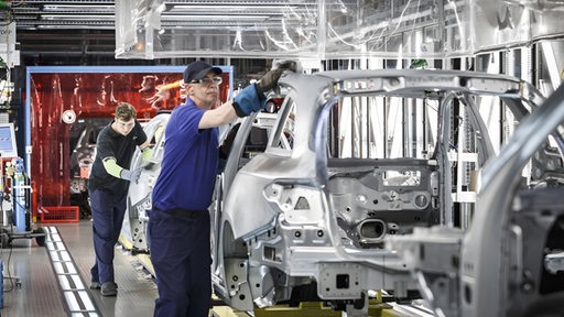 Arbeiter am Band bei Mercedes beim Rohaufbau der Autos.