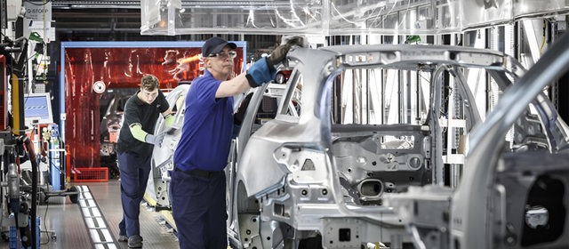 Arbeiter am Band bei Mercedes beim Rohaufbau der Autos.