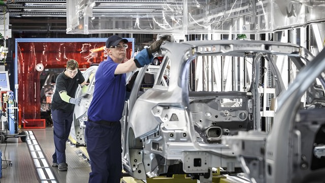 Arbeiter am Band bei Mercedes beim Rohaufbau der Autos.