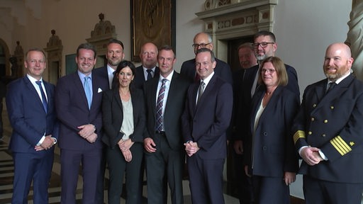 Ein paar Tage vor der Nationalen Maritimen Konferenz stehen mehrere Politiker nebeneinander. 