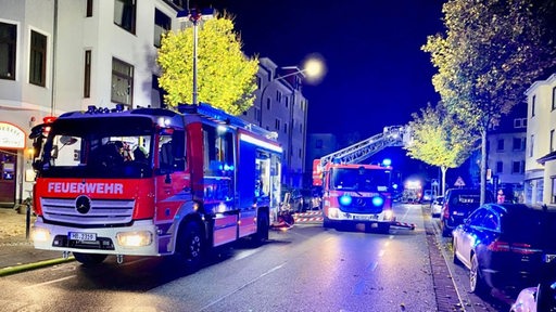 Feuerwehrleute stehen am Einsatzort.