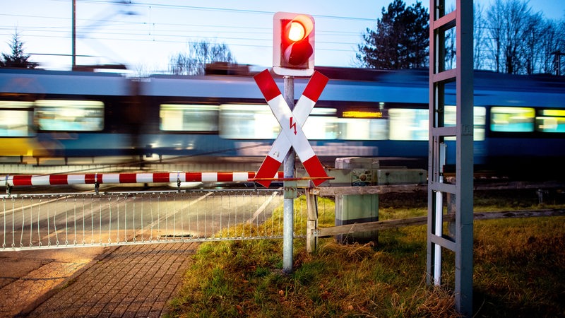 Zug passiert geschlossene Schranken